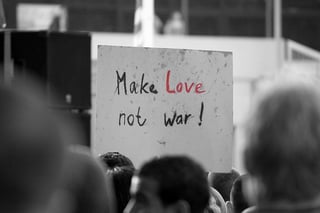 Learn from your competitors: make love not war sign in crowd